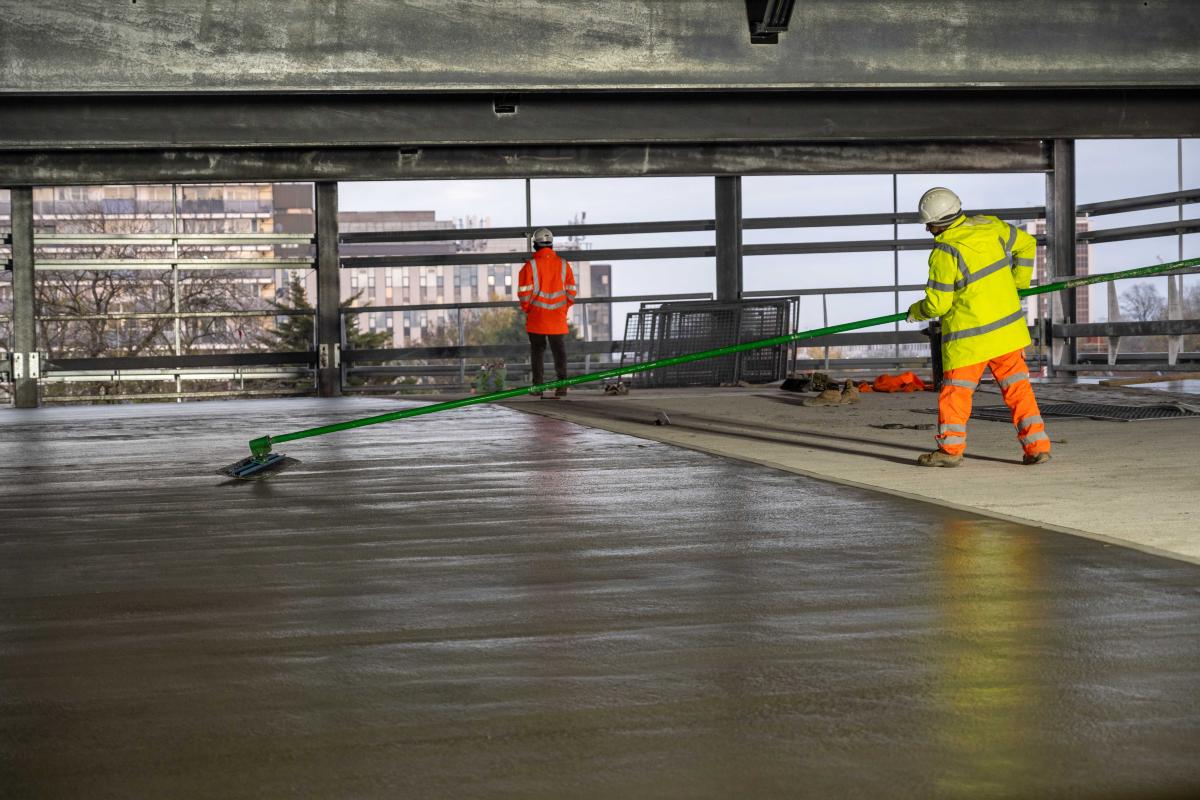 Construction workers prepare the ground surface