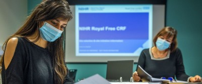 Two people reading documents in the Royal Free Clinical research Facility