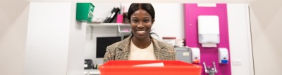 Woman smiling behind a desk with a box in front of her